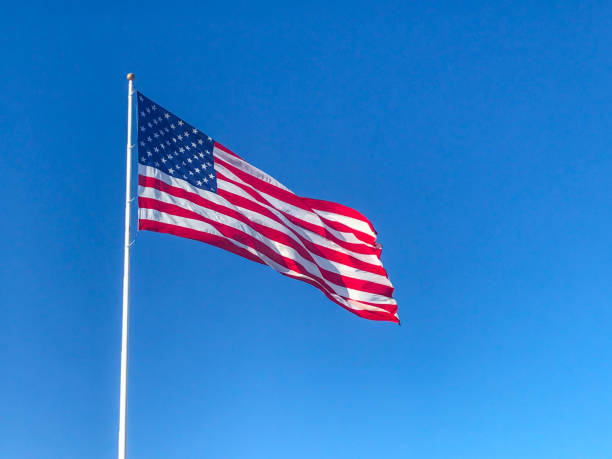 American flag waving in blue sky.