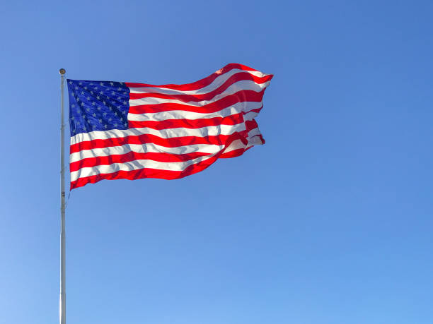 American flag waving in blue sky.