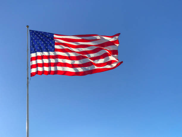 istock American flag waving in blue sky. 821942344