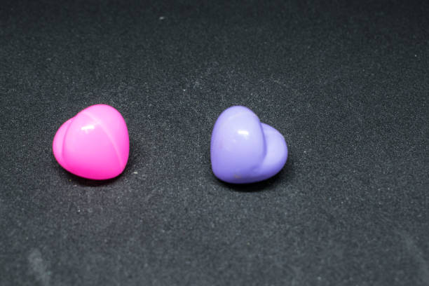 istock Pink plastic heart with purple Lay on a beautiful black background. 821946160