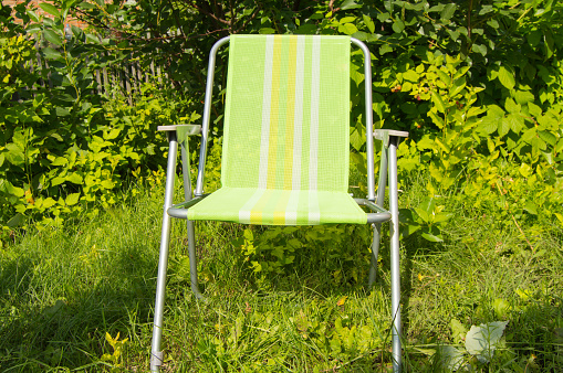 Folding chair for camping on green grass.