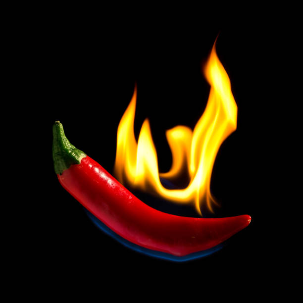 istock Red hot chili pepper isolated on black background with flame 821946926