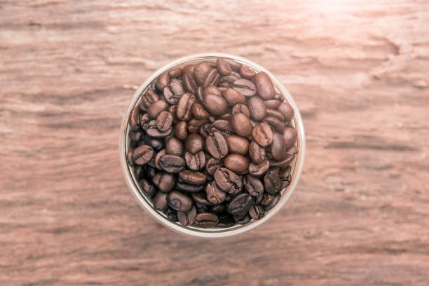 Top view of coffee. Coffee beans. Coffee cup full of coffee beans. Toned image. stock photo