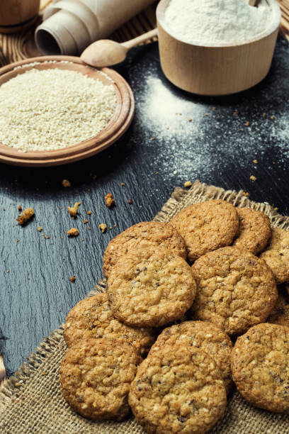 istock Biscuit sweet cookie background. Domestic stacked butter biscuit pattern concept,close up macro.Homemade cookies on wooden table.Cereal biscuits with the sesame,peanuts,sunflower and amaranth. 821955522