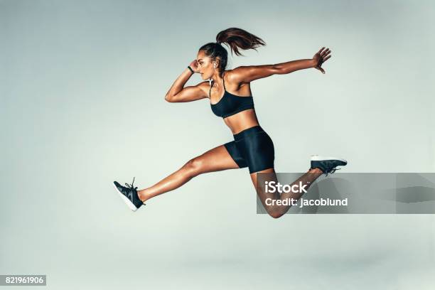 Fit Young Woman Jumping In Air Stock Photo - Download Image Now - Women, Jumping, Running