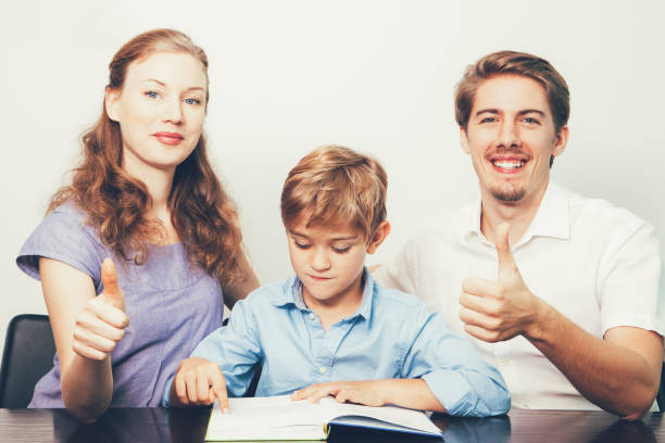 istock Mom, Dad and Son Reading Book With Thumbs Up 821962210