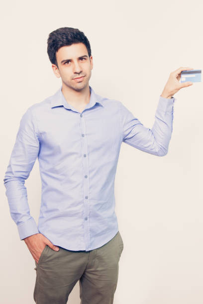 istock Serious Young Attractive Man Showing Bank Card 821962296