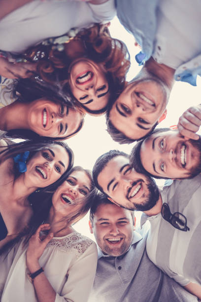 istock Group of Smiling Friends Creating Circle and Looking Down 821966240