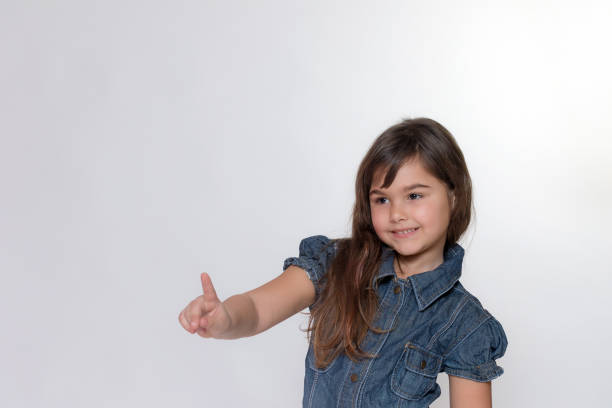 istock Smiling little girl is posing on the light gray background 821966288