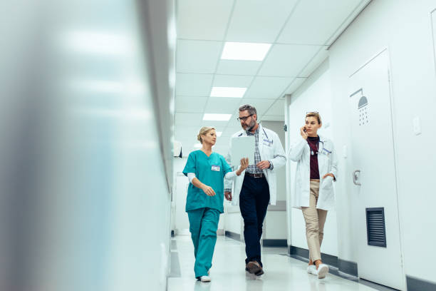 Group of medics discussing along hospital corridor