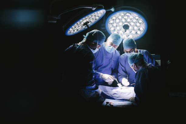 grupo de cirujanos en el quirófano del hospital - performance surgery doctor men fotografías e imágenes de stock