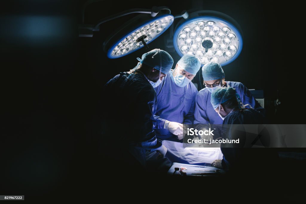 Group of surgeons in hospital operating theater Group of surgeons in hospital operating theater. Medical team performing surgery in operation room. Surgeon Stock Photo