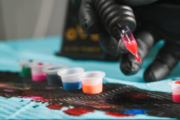 istock Tattoo artist refilling gun with ink 821967346