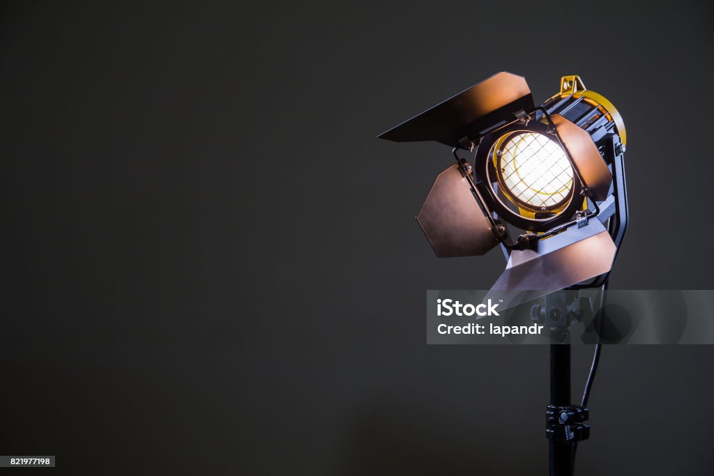 Floodlight with halogen lamp and Fresnel lens on a gray background. Lighting equipment for shooting. Filming and photographing in the interior Floodlight with halogen lamp and Fresnel lens on a gray background. Lighting equipment for shooting. Filming and photographing in the interior. Movie Stock Photo