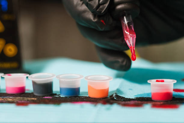 istock Tattoo artist refilling gun with ink 821988296
