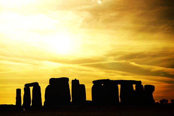 istock Stonehenge silhouette under bright orange sky/skies and clouds 822003860