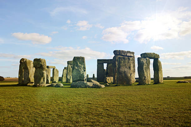 Stonehenge view under clear blue sky with clouds Stonehenge view under clear blue sky, clouds, and over green grass. çatalhöyük stock pictures, royalty-free photos & images