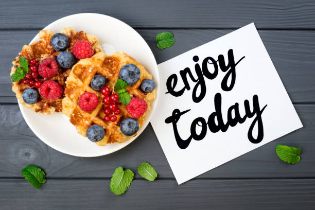 istock Traditional belgian waffles with berries and note Enjoy today. Breakfast concept. Flat lay, top view 822013172