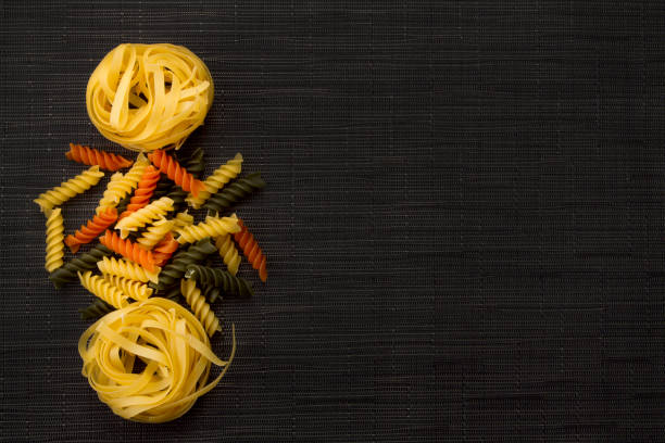 istock Raw Italian pasta view from above on black background. Pasta variations 822019884