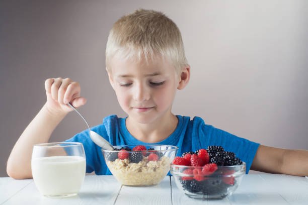 istock Little boy is eating oatmeal with berries. 822039972