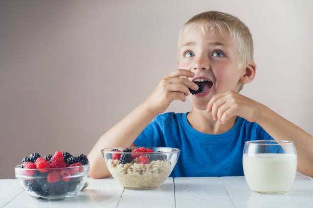 istock Little boy is eating oatmeal with berries. 822040012