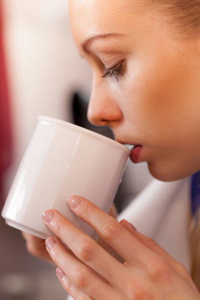 istock Closeup of woman drinking from white mug 822040398