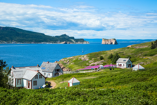 View of Perce Rock from Île-Bonaventure-et-du-Rocher-Percé National Park in Quebec, Canada.  The buildings of the National Park are in the foreground.