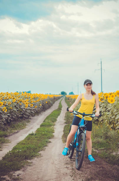 istock Young bicyclist riding in sunflower field 822070258