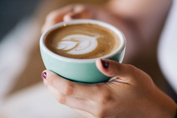 istock Close up of female hands holding cup of coffee 822086830