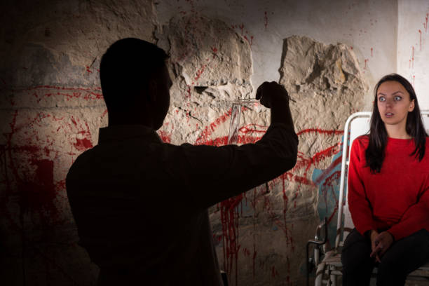 Shadowy figure pours liquid from beakers in front of patient