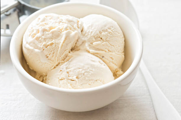 Vanilla ice cream scoops in white bowl stock photo