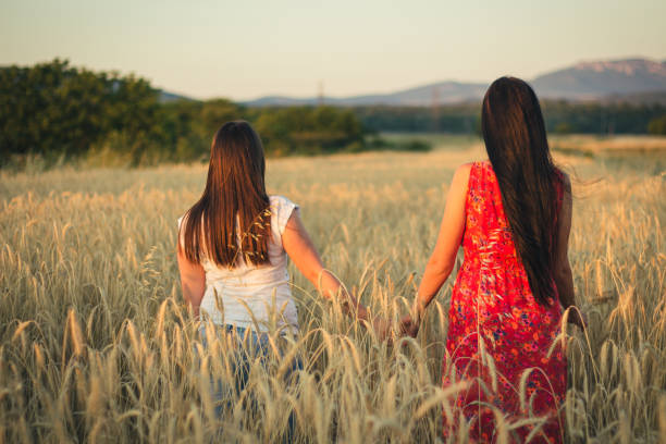 istock Two young women in field wheat holding hands. 822116246