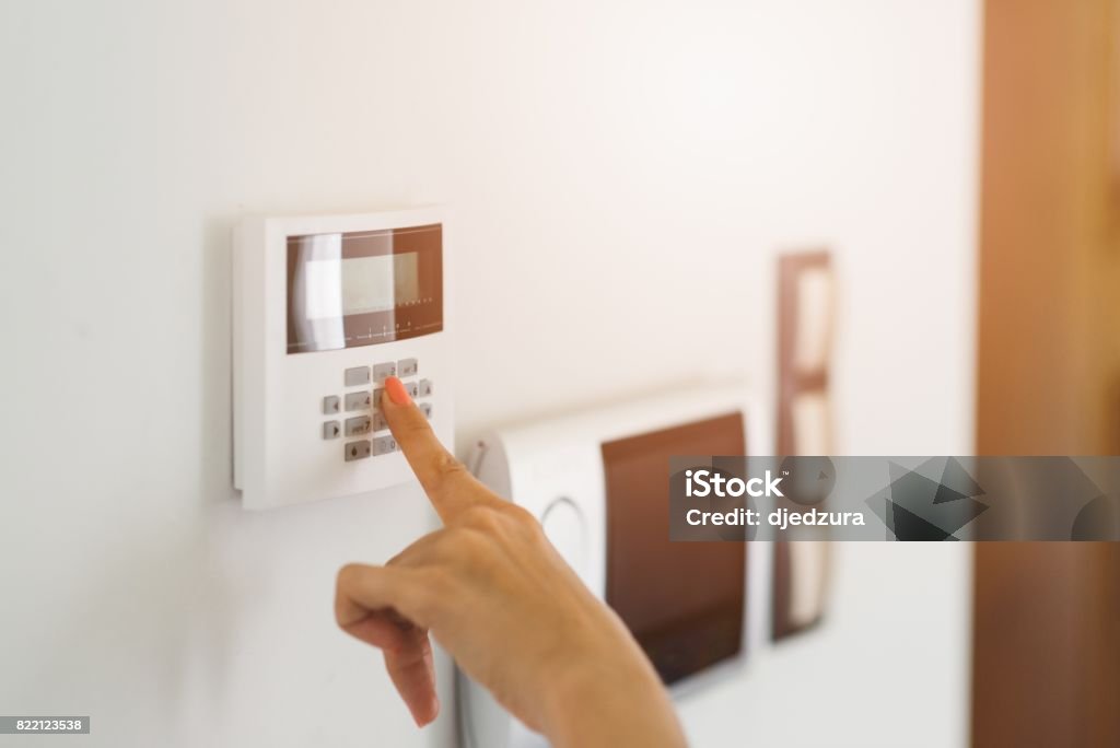 Young woman entering authorization code Young woman entering authorization code pin on home alarm keypad. Home security concept Domestic Life Stock Photo
