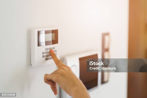Young Woman Entering Authorization Code Stock Photo - Download Image Now - Domestic Life, Alarm, Home Interior