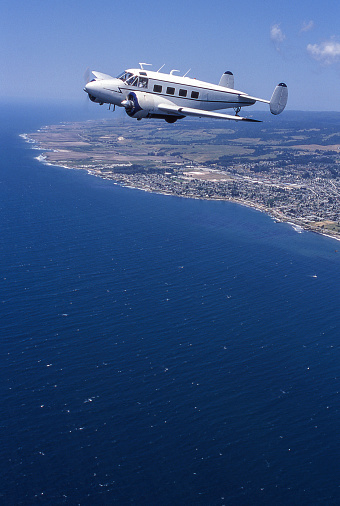 Lockheed 10 Electra plane flying over the coast of Santa Cruz CA
