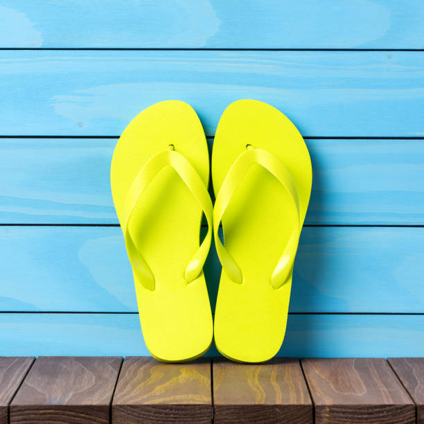 istock Green flip flops on wooden background. 822124746