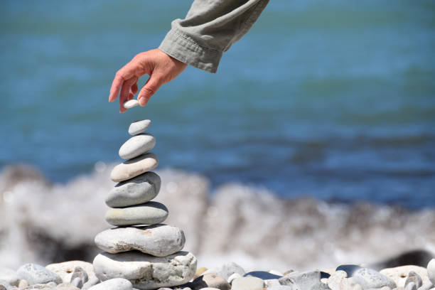 istock Person makes stone tower on the beach - just hand 822134854