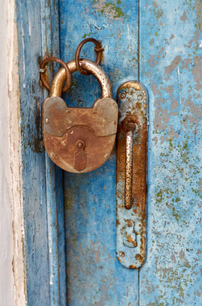 istock Old closed padlock rusty on wooden weathered door 822142748