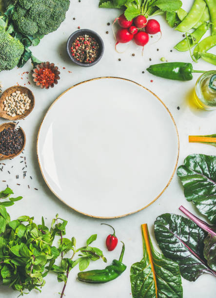 istock Fresh greens, vegetables and grains with white plate in center 822159422