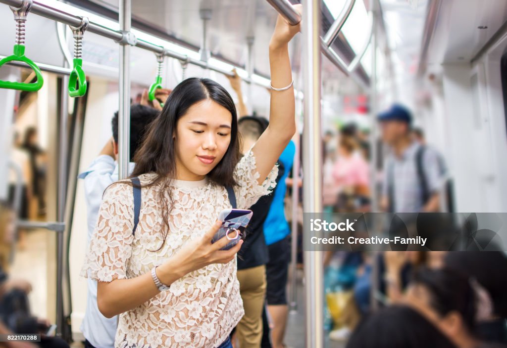 Asiatin mit Telefon in u-Bahn - Lizenzfrei Eisenbahn Stock-Foto