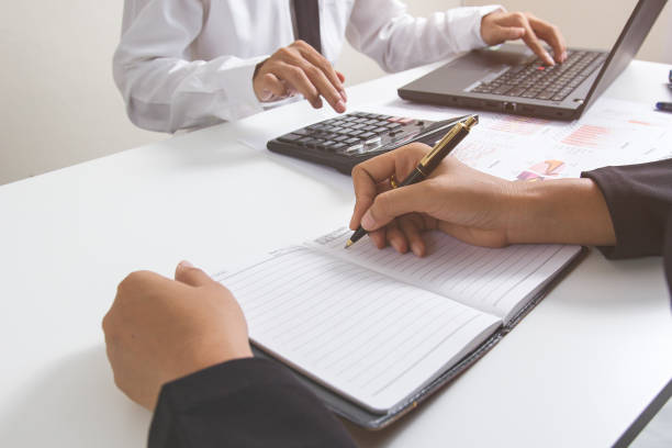 istock Businessman hand writing on notebook with finances paning about cost and businessman calculator and laptop with withe desk in modern office,Concept business and finance ,Account analyzes 822174046