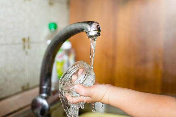 mano de un niño con contenedor bajo el agua - baby child poverty water fotografías e imágenes de stock