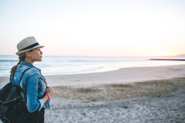 istock Young woman with backpack on the beach 822193164