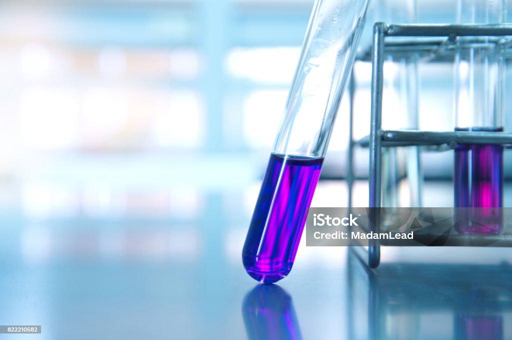 purple glass test tube and metal rack  in medical experiment science laboratory background purple glass test tube and metal rack  in medical experiment science with light laboratory background Purple Stock Photo