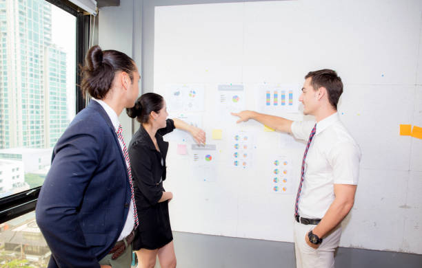 istock three business people in modern office looking report and analyzing with talking in meeting room. 822215092