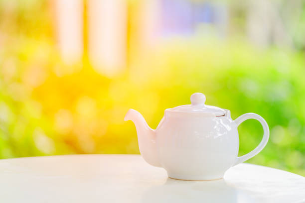 teapot on a blurred background of nature during breakfast in morning sunlight