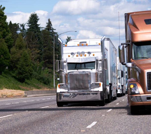 istock Classic big rig and modern semi truck with trailers going side by side on highway 822250244