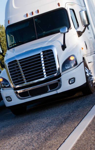 istock White modern semi truck with trailer driving with cargo on marked road 822253970