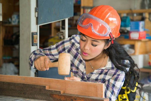 istock Asian pretty female carpenter Using wood hammer for wood. 822257106