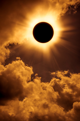 Natural phenomenon. Solar eclipse space with cloud. Abstract fantastic background - full sun solar eclipse glowing on sky and cloudy orange background. Outdoors.